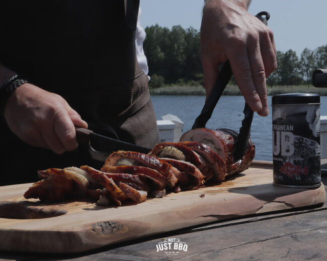 Slices of porchetta and rub Slicing porchetta from the barbecue