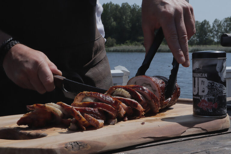 Slices of porchetta and rub Slicing porchetta from the barbecue